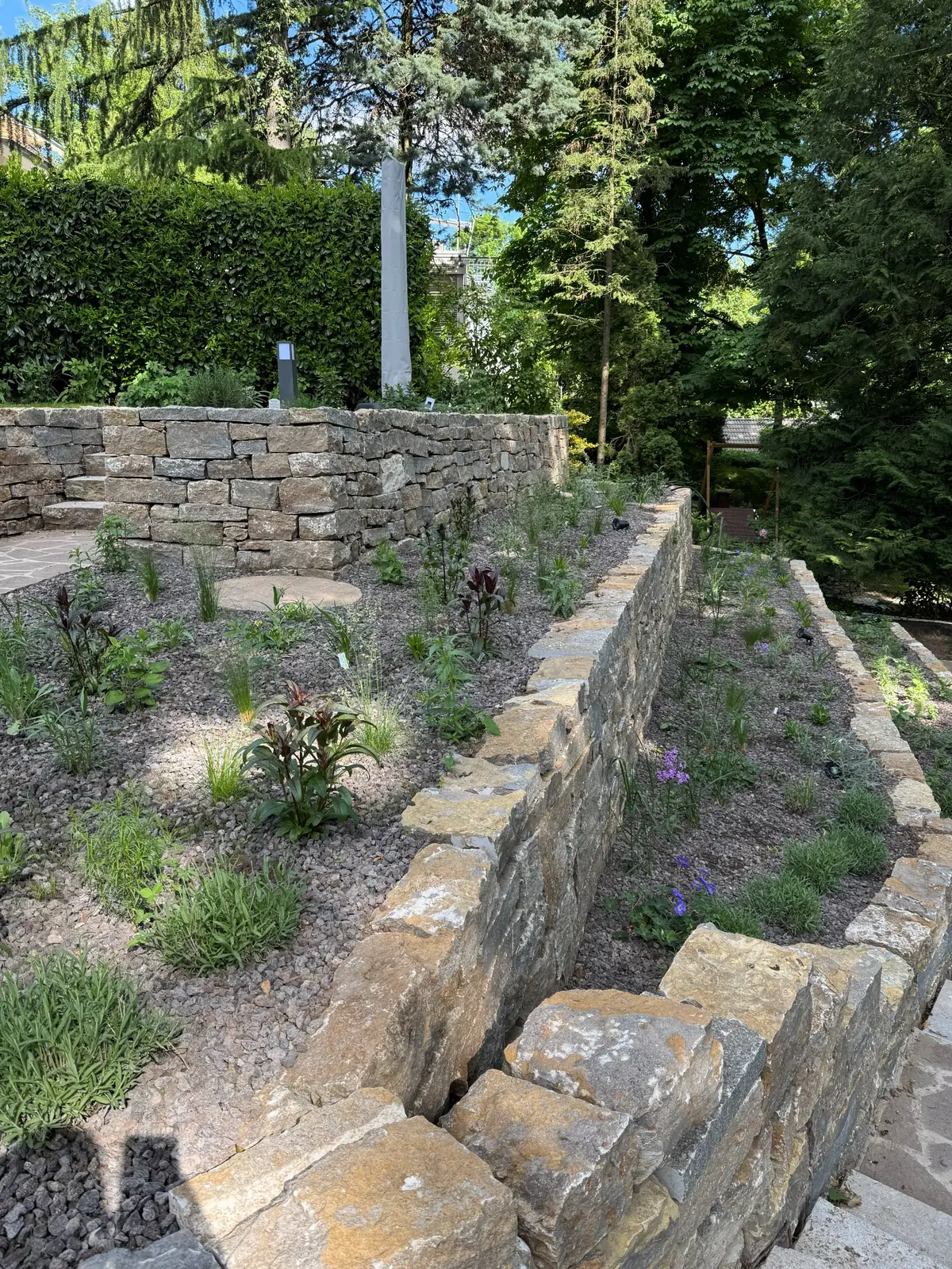 Bepflanzte, gestaffelte Natursteinmauern