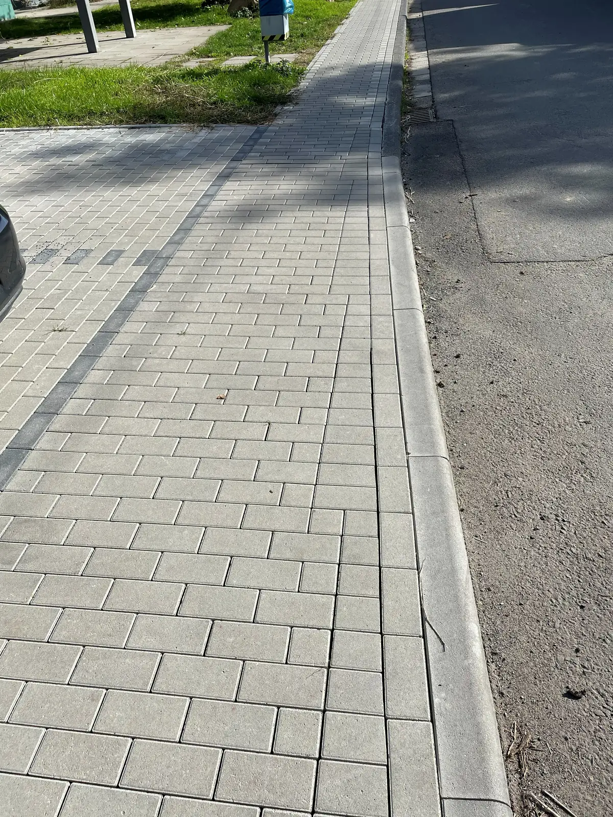 Entwässerungsrinne zwischen Pflasterfläche und Straße