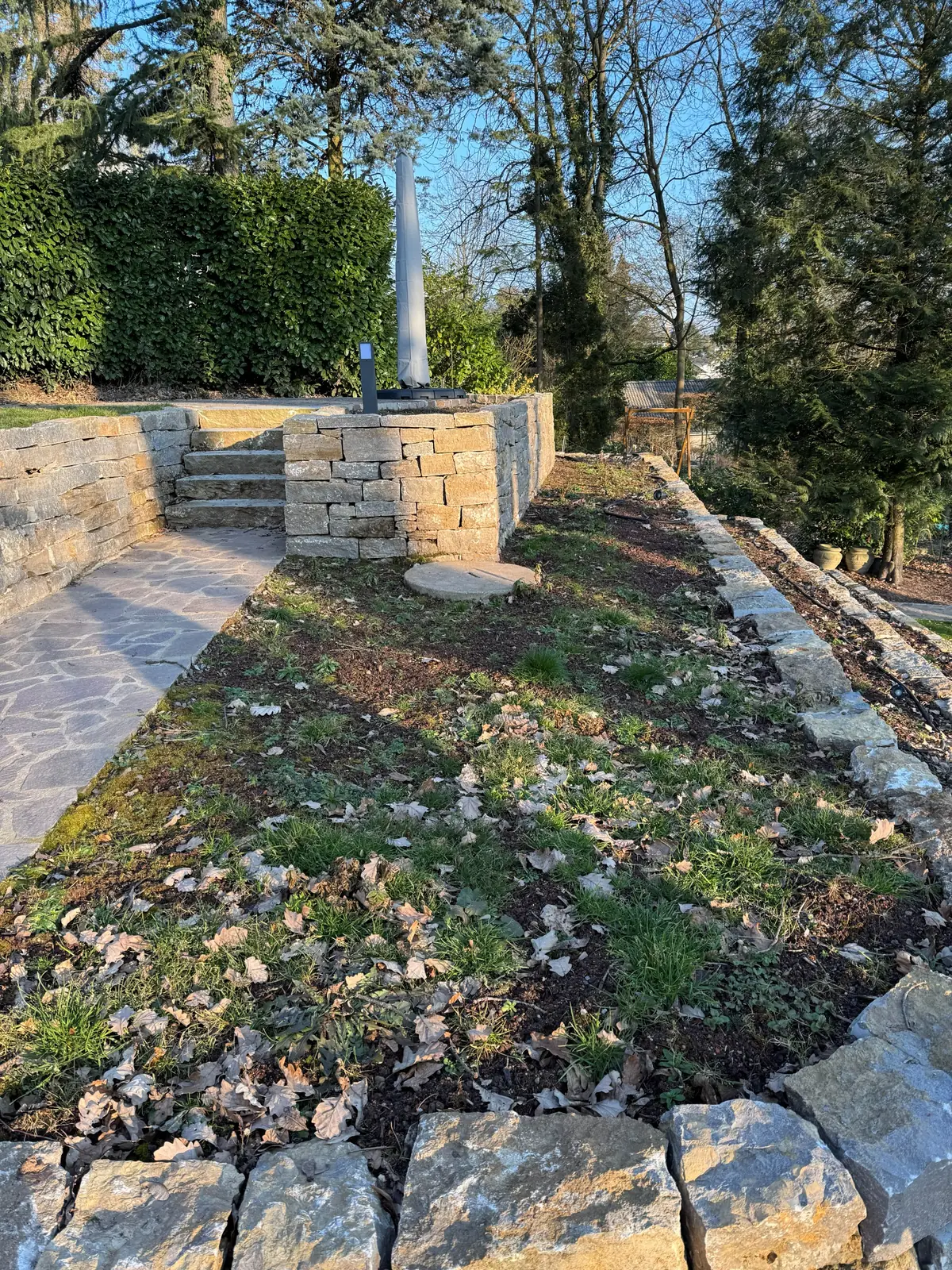 Hangbeet mit Natursteinmauern und Stufen