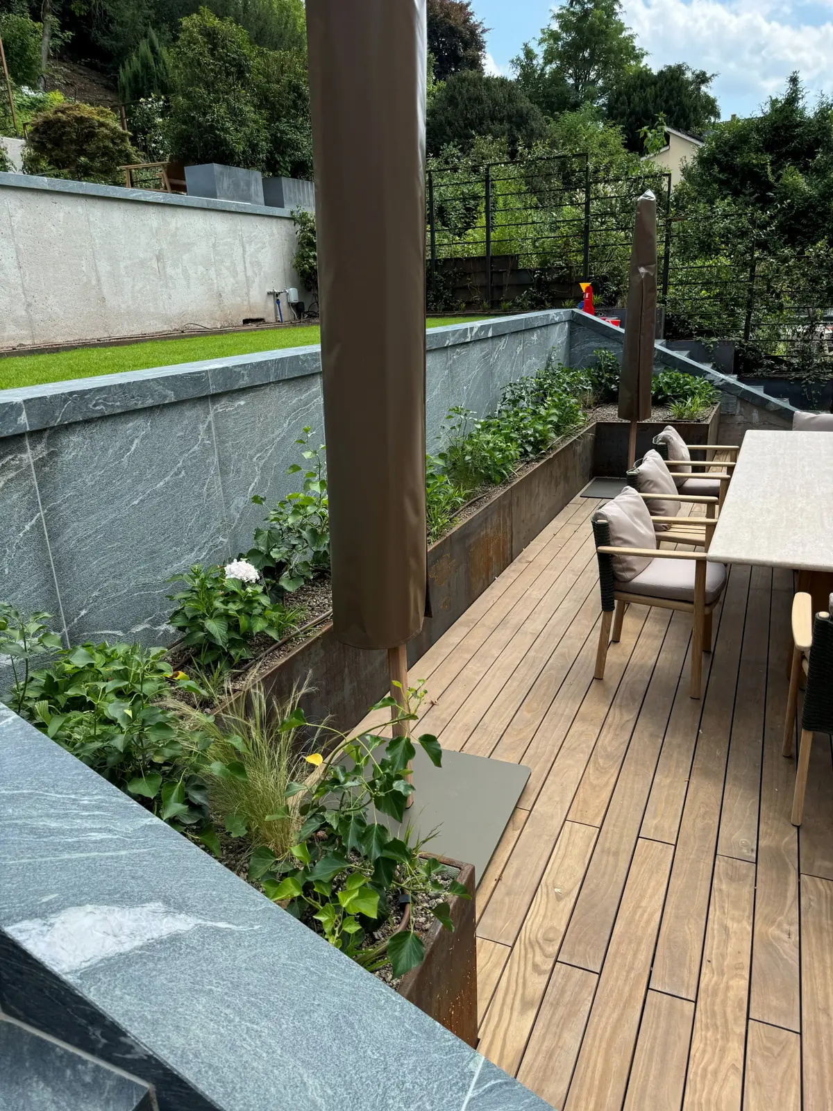 Terrassengarten mit WPC, Naturstein und Pflanzbeeten