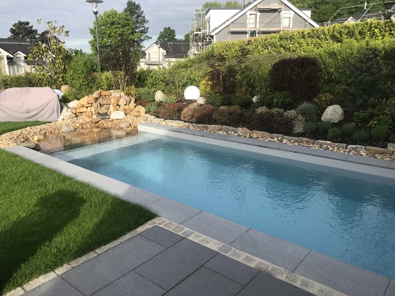 Poolgarten mit Rasen und Plattenterrasse